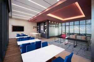 水原市Courtyard by Marriott Suwon的配有桌椅和电视的会议室