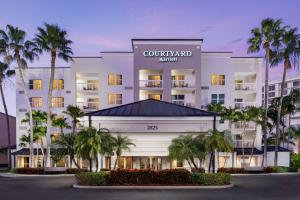 ein Hotel mit Palmen vor dem Hotel in der Unterkunft Courtyard by Marriott Miami Aventura Mall in Aventura