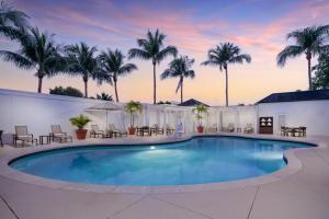 ein Pool mit Palmen im Hintergrund in der Unterkunft Courtyard by Marriott Miami Aventura Mall in Aventura