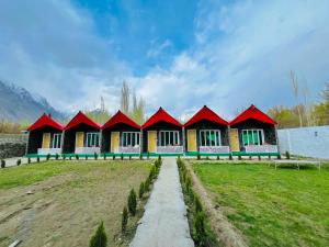 a row of houses with red roofs in a field at Royal Guest House in Skardu
