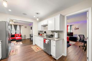 a kitchen with white cabinets and a living room at Rose’s Lair in Atlanta(ATL) Near Downtown/Midtown/MARTA/Hartsfield-Jackson Airport in Atlanta