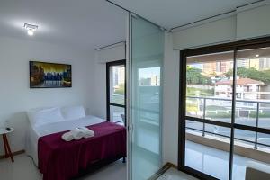 1 dormitorio con 1 cama y puerta de cristal en H.E 301 · Lindo Apt com Varanda - Caminho das árvores en Salvador
