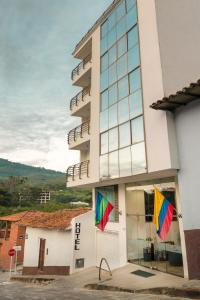 a building with two flags in front of it at Hotel Puerto Bahia in San Gil