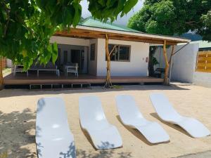 a group of white chairs in front of a house at Fare Orahana Moorea in Afareaitu
