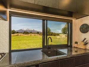 a kitchen with a window with a view of a mountain at Sno Ruapehu - Horopito Holiday Home in Raetihi