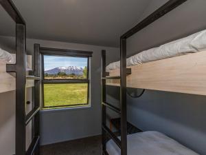 Cette chambre comprend 2 lits superposés et une fenêtre. dans l'établissement Sno Ruapehu - Horopito Holiday Home, à Raetihi