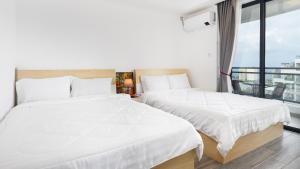 - 2 lits dans une chambre avec fenêtre dans l'établissement STAR BAY Residence Sihanoukville - 400m to Sokha Beach, à Sihanoukville