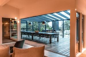 a dining room with a table and chairs on a deck at Winifred in Red Hill South