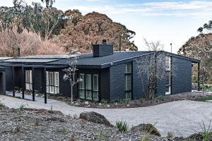 a black house with a black roof at Winifred in Red Hill South