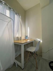 einen Schreibtisch in einem Zimmer mit einem Stuhl und einem Bett in der Unterkunft Elise's Exclusive Escape - Amaia Altaraza San Jose Del Monte Bulacan in Tunkong Manga