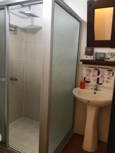 a bathroom with a sink and a glass shower at Hostal Santa Clara B&B in Apaneca
