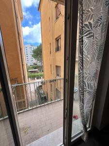 eine offene Tür zu einem Balkon mit Blick auf ein Gebäude in der Unterkunft Appartamento clarissa in Alassio