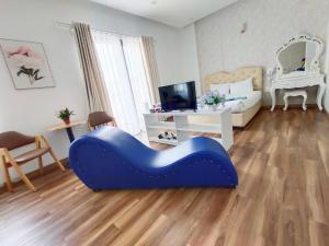 a bedroom with a blue couch in the middle of a room at Ngan Pho Studio & Hotel in Da Lat