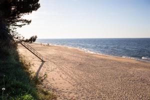 uma praia de areia com pessoas a caminhar sobre ela junto ao oceano em GooseHaus em Gąski