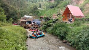a group of people are rafting down a river at Camping Pines singkur reverside in Bandung