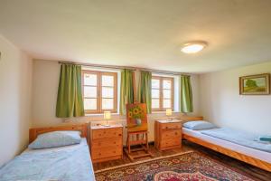 a bedroom with two beds and two windows at Alandblick Apartments in Wanzer