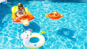 a woman sitting on a raft in a swimming pool at Holiday Inn Auckland Airport by IHG in Auckland