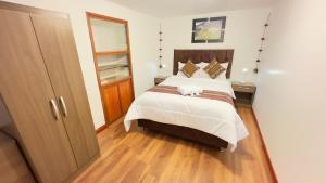 um quarto com uma cama grande e piso em madeira em Casona Liberty Inn em Cusco