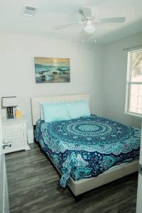 a bedroom with a bed with a blue quilt at Happy Beach House in Biloxi in Biloxi