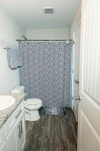a bathroom with a toilet and a shower curtain at Happy Beach House in Biloxi in Biloxi
