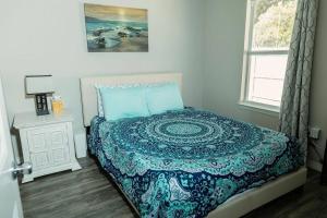 um quarto com uma cama com uma colcha e uma janela em Happy Beach House in Biloxi em Biloxi