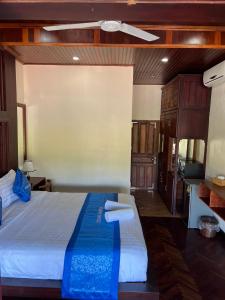 a bedroom with a large bed with towels on it at NamKhan Riverside in Luang Prabang