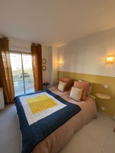 サント・マキシムにあるSuperbe 70m2 avec terrasses, proche de la plageの大きなベッドと大きな窓のある寝室