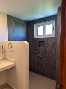 a bathroom with a refrigerator and a window at Oneiro Suites with Sea View in Mahahual