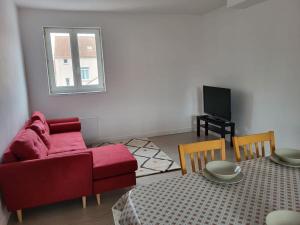 - un salon avec un canapé rouge et une table dans l'établissement 70 m² spacieux et lumineux, à Calais
