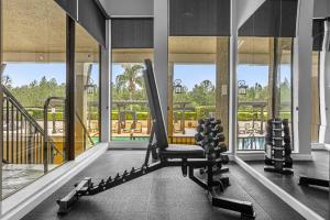 a gym with a chair in a room with windows at 4BR 4 Baths Townhouse 1 Mile to Disney with Pool, Gym, & Jacuzzi in Orlando