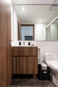 a bathroom with a sink and a toilet and a mirror at Amazing 2BR in Condesa in Mexico City