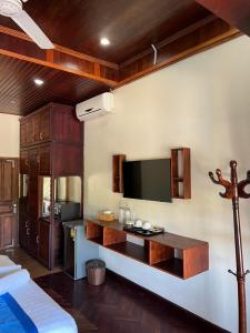sala de estar con TV y mesa en una habitación en NamKhan Riverside en Luang Prabang