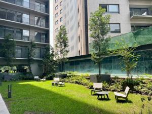 a park with chairs and tables in front of a building at Amazing 2BR in Condesa in Mexico City