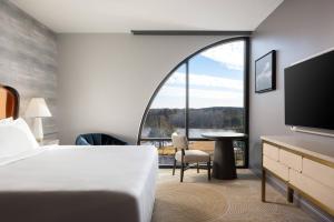 ein Hotelzimmer mit einem Bett und einem großen Fenster in der Unterkunft Trilith Guesthouse, Fayetteville, GA, a Tribute Portfolio Hotel in Fayetteville