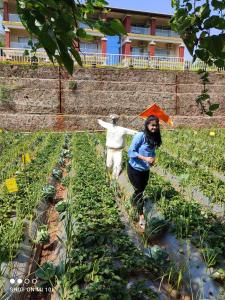 two people walking in a field with an umbrella at Khushi Riverside Resort & Spa in Mahabaleshwar