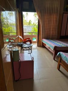 a bedroom with a bed and a table and chairs at San Vuon Guesthouse in Mui Ne