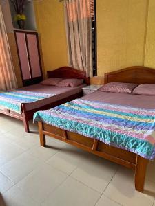 two beds sitting in a room with at San Vuon Guesthouse in Mui Ne