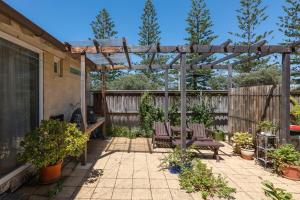 un patio con 2 sillas y una pérgola de madera en Bronte Boho Chic near Ocean with Parking en Sídney