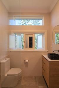 ein Bad mit einem WC, einem Waschbecken und einem Fenster in der Unterkunft Bronte Boho Chic near Ocean with Parking in Sydney