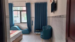 a room with blue chairs and a window at Khách Sạn Nguyên Trung in Ho Chi Minh City