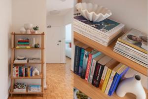 een boekenplank met boeken en een vaas erop bij Stylish Sun Drenched North Bondi Beach Oasis in Sydney