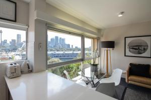 eine Küche mit einem großen Fenster sowie einem Tisch und Stühlen in der Unterkunft The Gem-Executive Potts Point Harbourview Stunner in Sydney