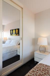 uno specchio in una camera con letto e lampada di The Gem-Executive Potts Point Harbourview Stunner a Sydney