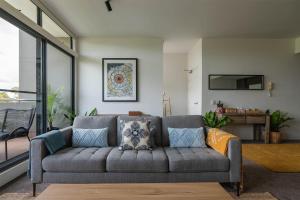 a living room with a gray couch with pillows at Treetops Camperdown Inner City Bliss w Parking in Sydney
