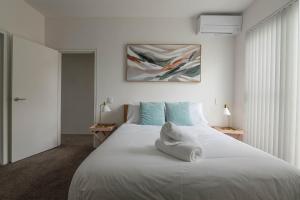1 dormitorio con 1 cama blanca grande con almohadas azules en Treetops Camperdown Inner City Bliss w Parking, en Sídney