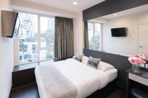 ein Schlafzimmer mit einem großen Bett und einem großen Fenster in der Unterkunft Value Hotel Nice in Singapur