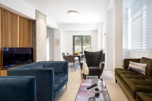 a living room with two couches and a table at Heart of Tel Aviv Garden Oasis by Sea N' Rent in Tel Aviv