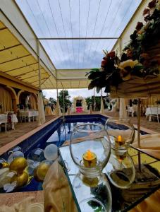 - une piscine avec deux vases et une table avec des bougies dans l'établissement Hotel Oasis Villa, à Tsqaltubo