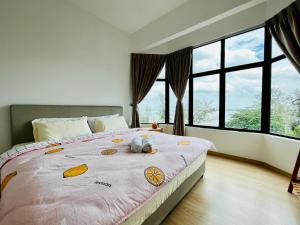 Netflix-Seaview-SunsetView-PuteriBeach-Mutiara Beach Resort Melaka في Kampong Pantai Dusun: غرفة نوم مع سرير مع اثنين من الحيوانات المحشوة عليه