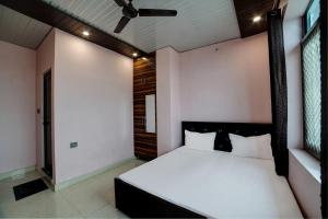 ハルドワニにあるOYO Bharat Mart Hotel Guest Innのベッドルーム1室(ベッド1台、シーリングファン付)